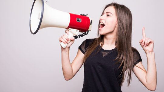lady with brown hair shouting into megaphone, advocating for a brand