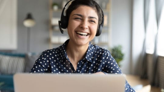 woman wearing headset using laptop video stream conference call