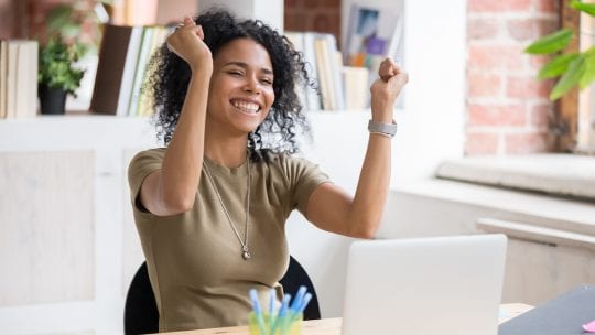 woman excited in front of laptop