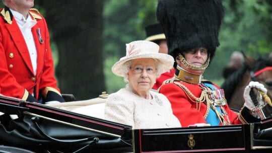 The Queen of England rides in a carriage