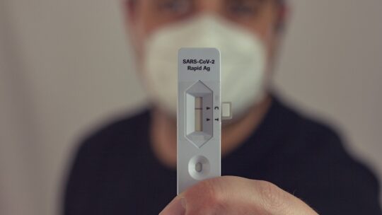 Man holds up a COVID rapid test