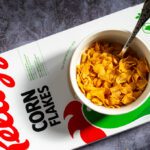 Top view of a Kellogg's Corn Flakes package, with a bowl being prepared from above