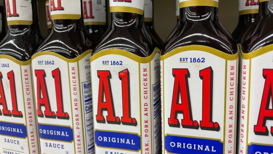 Grocery store shelf with A.1. steak sauce bottles, side view